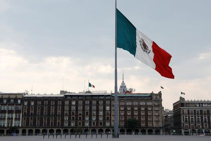 Foto ilustrada de la bandera mexicana en la capital del país (Foto de Carlos Iasso / REUTERS)