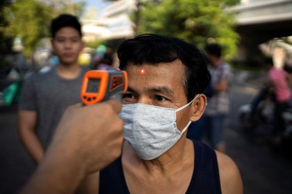 Un hombre con una máscara de coronavirus usa una máscara en un templo en Bangkok, Tailandia (REUTERS / Athit Perawongmetha)