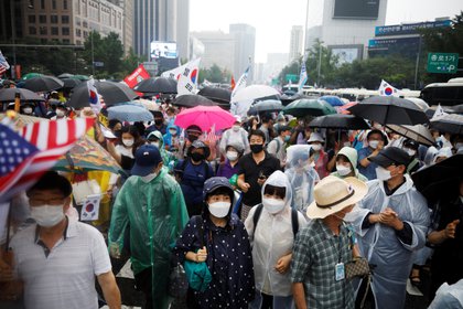 Miembros de grupos cívicos conservadores marchan en la calle de Seúl contra las protestas antigubernamentales en medio de brotes inadvertidos de coronavirus (REUTERS / Kim Hong-Ji)
