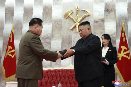 En una foto proporcionada por el gobierno norcoreano este domingo 26 de julio, el dictador norcoreano Kim Jong Un entregó una pistola a un oficial del ejército durante una ceremonia en Pyongyang.  A la derecha está la influyente hermana de Kim, Kim Jong Un (AP)